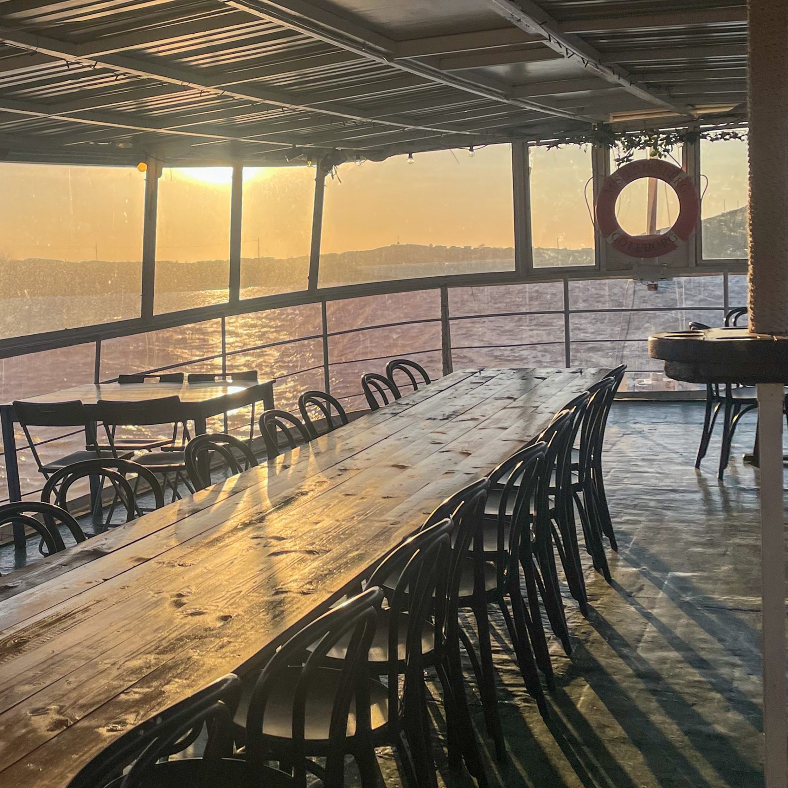 Långbord dukat i salongen ombord i kvällssol